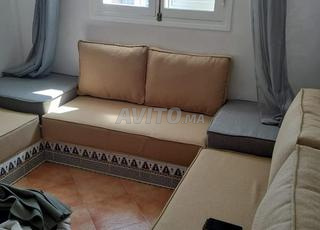 coin salon en L avec coussins beiges et base grise