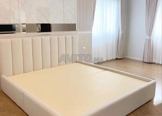 grand lit au cadre capitonné de couleur crème