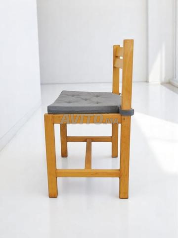 كرسي عتيق من الخشب الصلب مع وسادة زرقاء