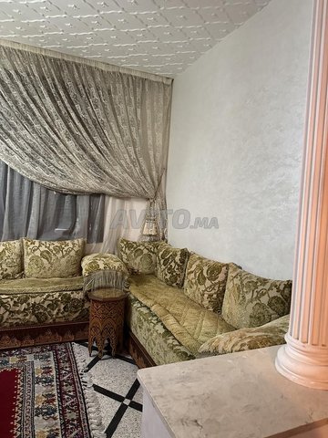 Salon marocain avec rideaux,tapis,lustre et tables