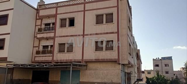 Maison à trois étages et quatre grands commerces. 