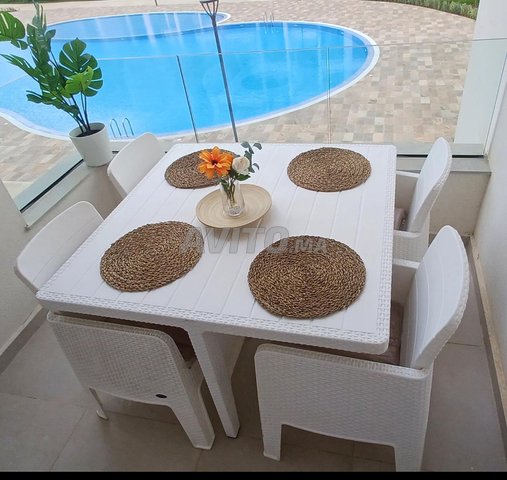 Table avec 4 chaises en résine tressée blanche