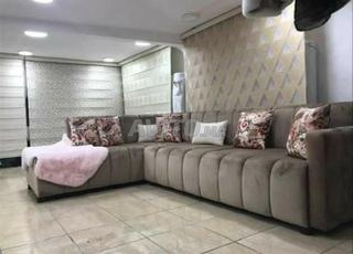 Canapé d’angle beige avec coussins floraux