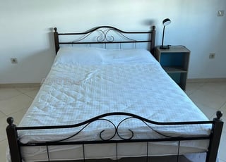 Lit double avec matelas, table de chevet et lampe