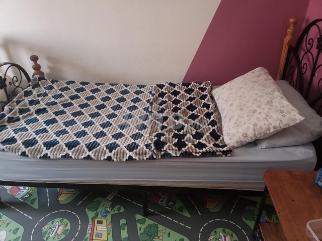 سرير مع فراش وطاولة ليلية