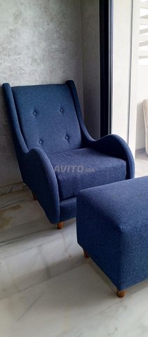 كرسي بذراعين من القماش ومسند القدمين الخاص به