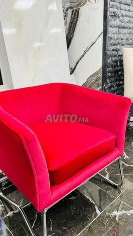 كرسي بذراعين منجد باللون الأحمر