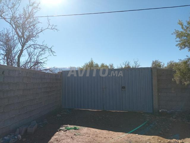 Terrain avec maison, poulailler et entouré d'un mur