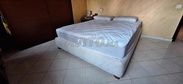 Grand lit 2 places avec sommier lourd tapissé.