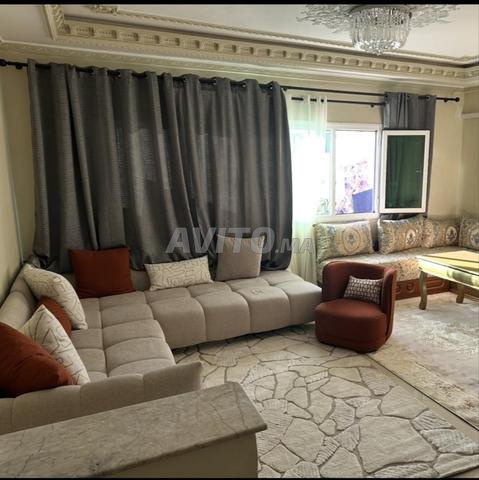 كنبة على شكل حرف L وكرسي بذراعين مع سجادة