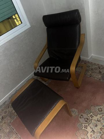 كرسي "إيكيا" من الجلد الأسود مع مسند قدم مريح
