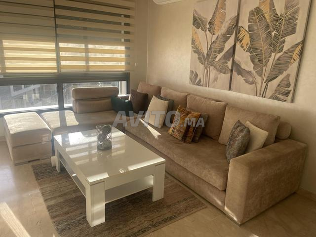 صالون على شكل حرف L بيج وطاولة بيضاء للبيع