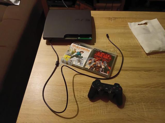 Ps3 slim avec et une manette noire et deux disques