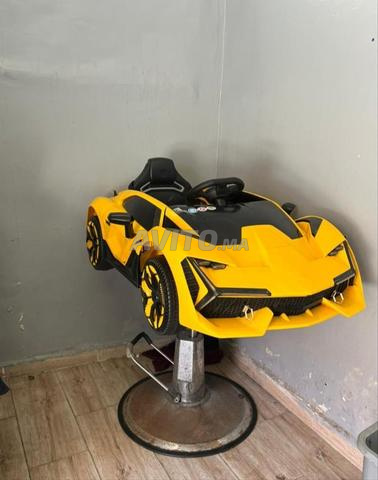 كرسي حلاقة على شكل سيارة، وفي نفس الوقت يتحول إلى لعبة