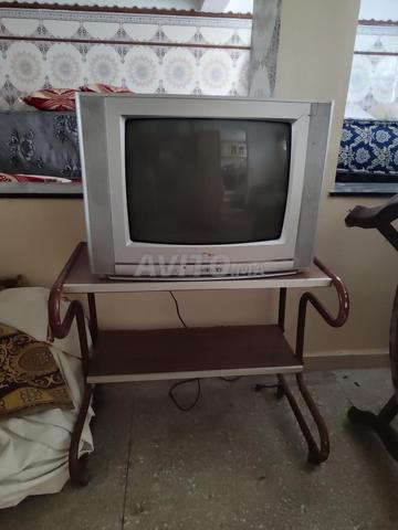 تلفازة بالطاولة الخاصة بها