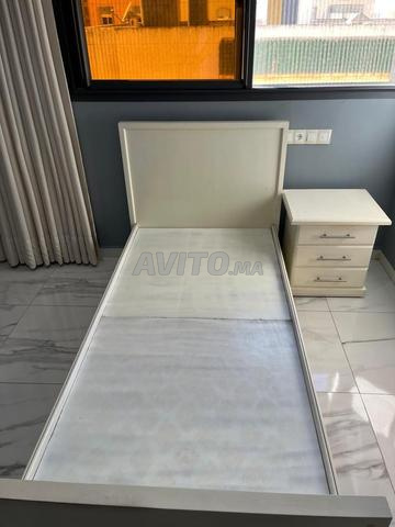 Deux lits avec table de chevet au centre