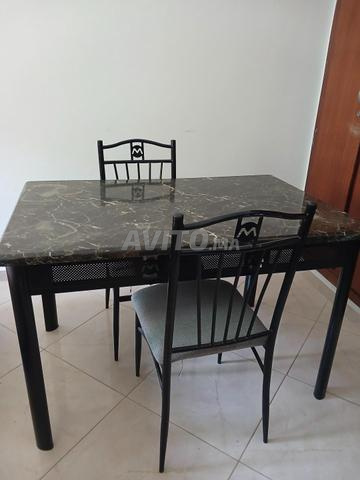 Table en fer forgé avec deux chaises.