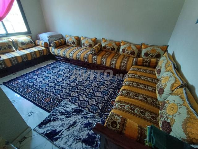 Salon à vendre avec coussins décorés et tapis