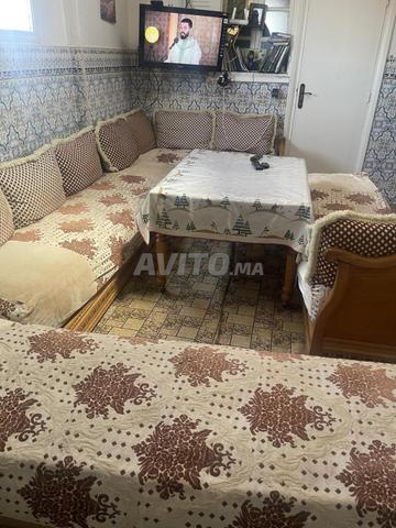 Salon en bon état avec moquette et table