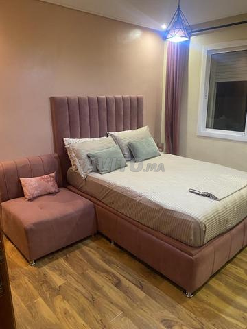 Un lit avec coffre, fauteuil et commode