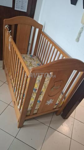 Lit bébé en bois solide avec matelas en bon état.