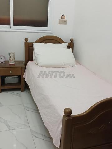 سرير مع مرتبة وطاولة بجانب السرير