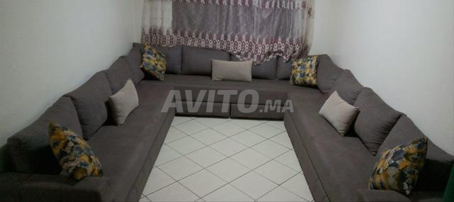 Je vends un grand salon en U de couleur grise.