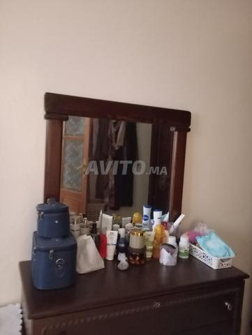 Armoire miroir encore neuve et une étagère avec photos