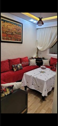 Salon marocain moderne rouge avec coin et table
